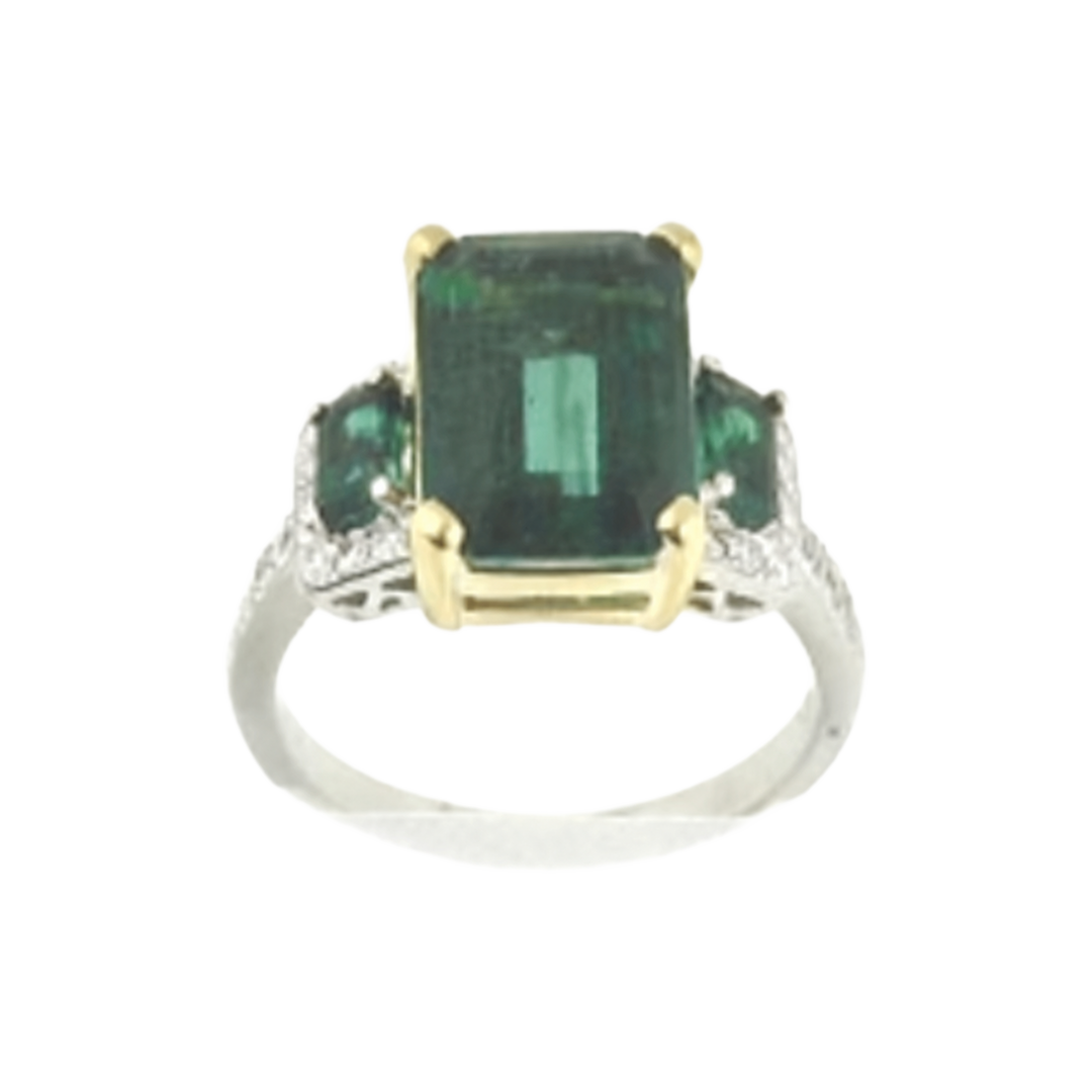 Ring with a rectangular green center stone, two smaller green side stones, yellow-tone prongs and white-tone shoulders.