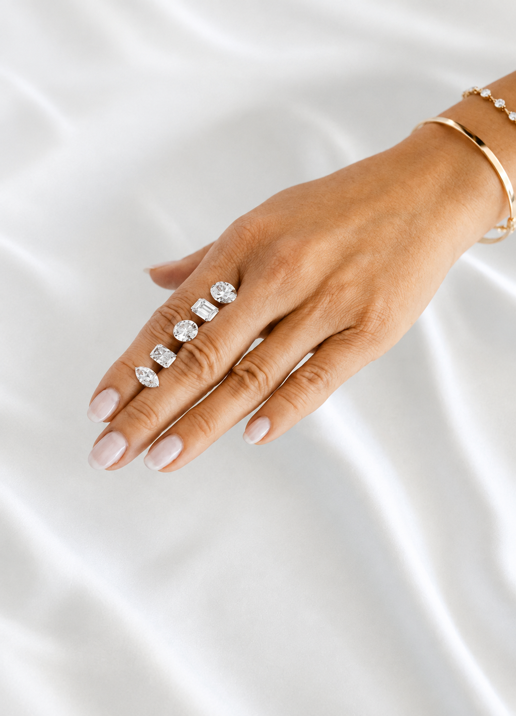 Diamond rings on a hand against soft white fabric